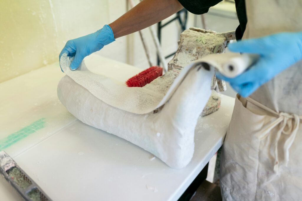 Close-up of an orthotic technician crafting a custom brace in a workshop environment.